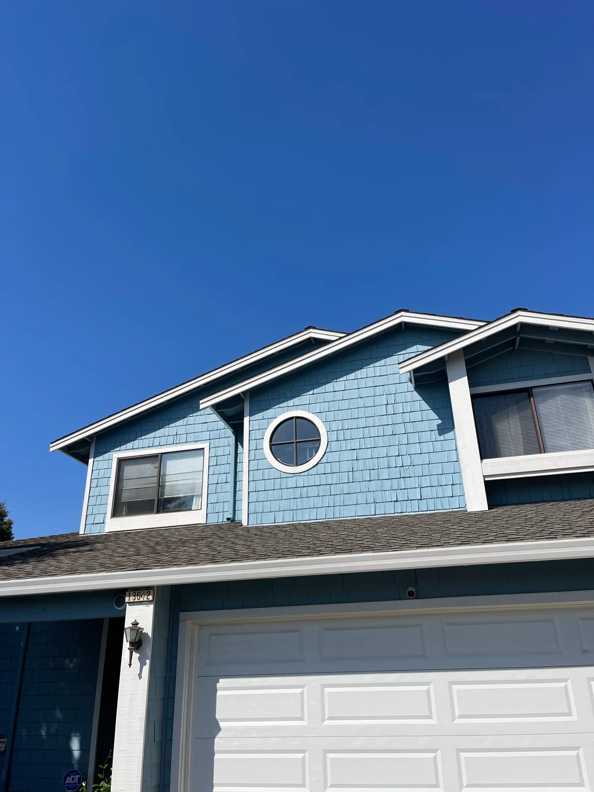 Fresh blue exterior and white trim on a Planet Painting house project